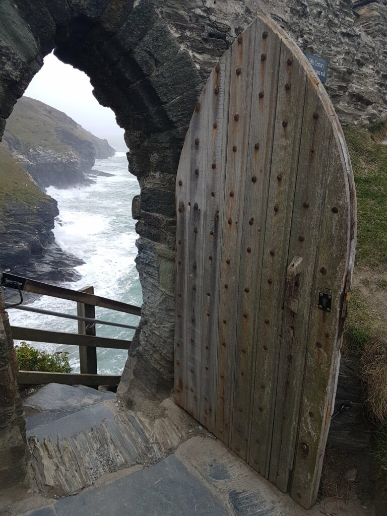 Alte Holztür von Tintagel Castle mit Blick auf die Felsenküste und den Atlantik