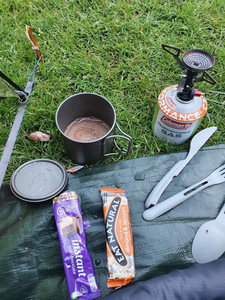 Camping cooker with instant cocoa and an energy bar